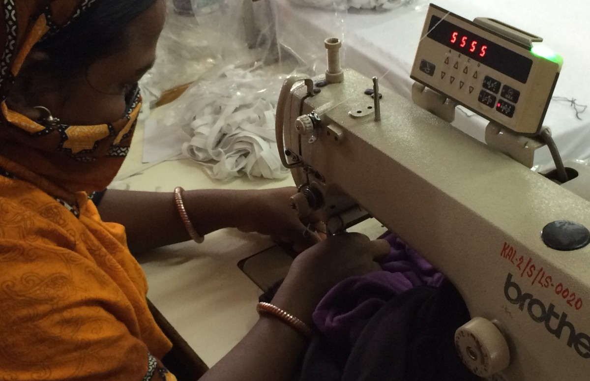 Woman sewing in garment factory.