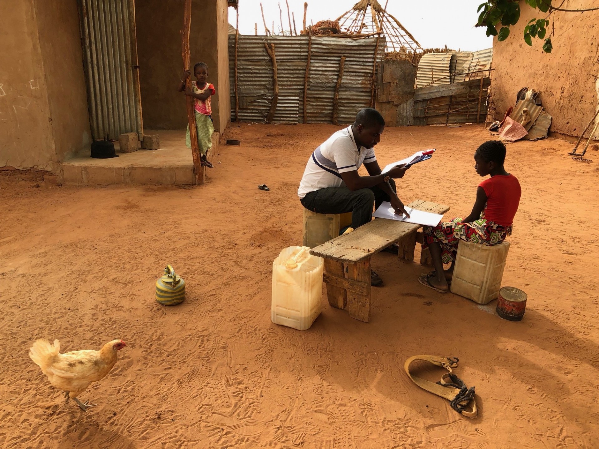 A person tutoring child in a backyard